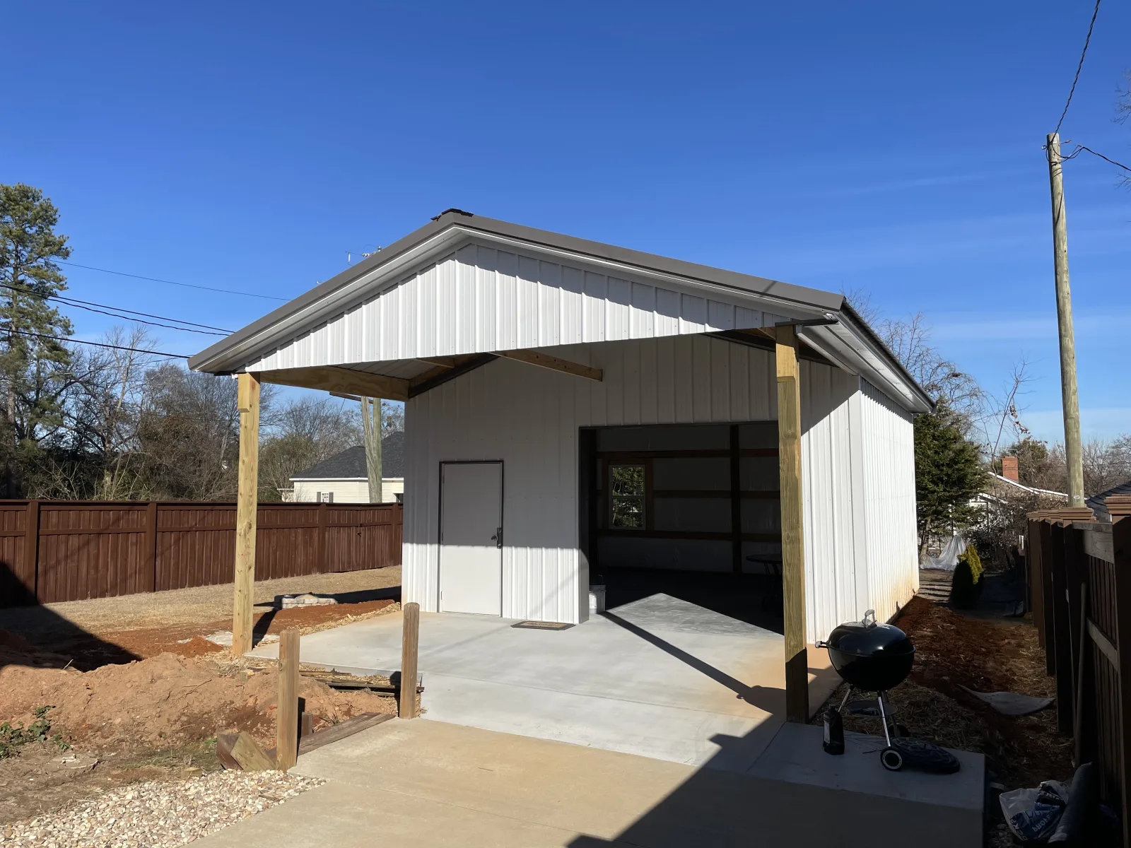Custom pole building garage with a covered roof extension, built by Hoover Building Systems